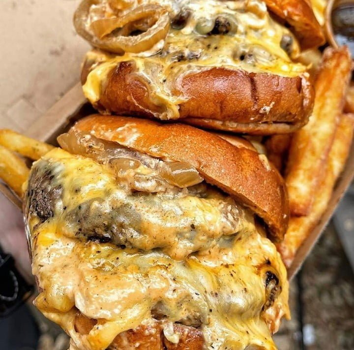 Two Beef burgers with plentiful gooey cheese